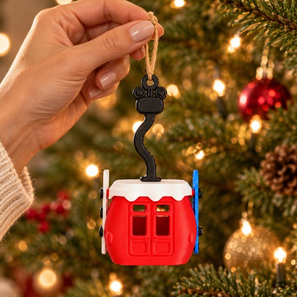 Hand holding the gondola ornament by its twine loop, showing its size of about four inches